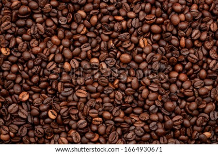 Energy stimulant and smooth java concept with full frame photograph of piled roasting coffee beans backgrounds