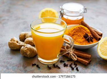 Energy tonic drink with turmeric, ginger, lemon and honey on a grey concrete background