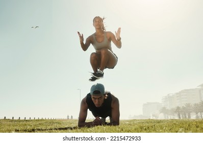 Energy, Training And Intense Couple Workout In A Park With Serious, Cool And Wellness In Nature. Cross, Different And Fit Jumping Woman With Man Doing Ground Pushup In Extreme Physical Exercise