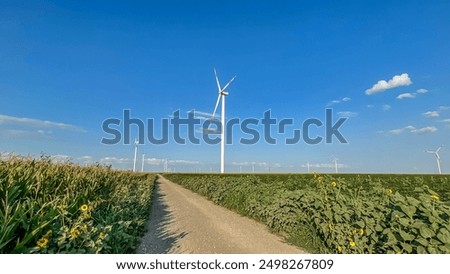 An energy windmill using wind power. An electric power generator is a wind turbine. A modern ecological power plant. A windmill in the field of Europe. Renewable energy. Electricity generation.