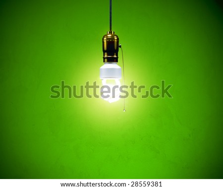 Energy-efficient CFL bulb shining at center from a simple brass fixture. Green background slightly textured.