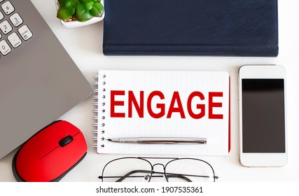ENGAGE text on notepad,pen, office tools on the white background. Business