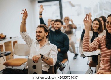 An engaged audience participating in a QA session at a workshop. People with raised hands are eager to interact, contribute or ask questions. - Powered by Shutterstock