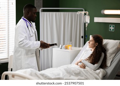 Engaged in a conversation with the young patient, the African doctor holds a folder, discussing her well-being and noting any changes in her condition while she rests in the hospital bed. - Powered by Shutterstock