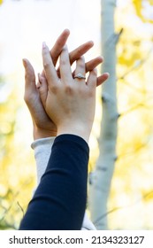 Engaged Couple Holding Hands Up In The Air 