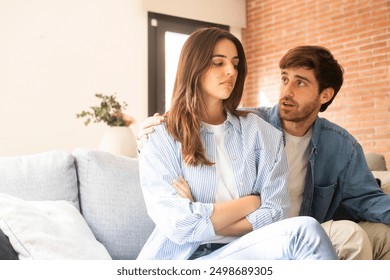 Engaged couple with relationship problems sitting on the sofa with their backs to each other after an argument, conflicts in marriage, upset couple after a dispute, making decision to break up divorce - Powered by Shutterstock