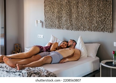 Engaged Couple Sleeping Cuddled In A Bed During A Vacation