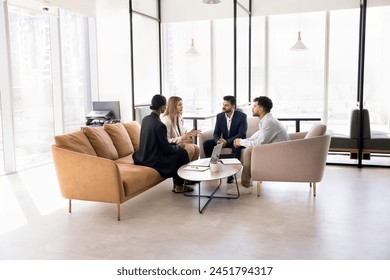 Engaged multiethnic business team sitting in circle on couch, in armchairs in office co-working space, discussing teamwork strategy, solutions for project, talking on collaboration, brainstorming - Powered by Shutterstock