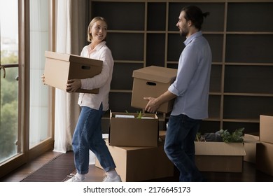 Engaged Positive Millennial Couple Talking, Chatting, Laughing, Carrying Paper Boxes, Moving Into New Home. House Buying, Apartment Rent, Relocation, Renovation Concept