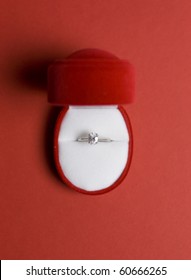 An Engagement Diamond Ring In A Red And White Gift Box Placed On Red Background, Top View.