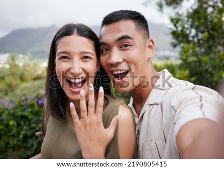 Engagement, ring and celebration with a young couple announcing their happy news and special occasion. Closeup portrait of a man and woman taking a selfie after getting engaged to be married outside