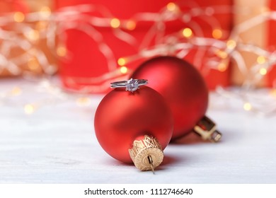 Engagement Ring And Christmas Balls On Table, Closeup