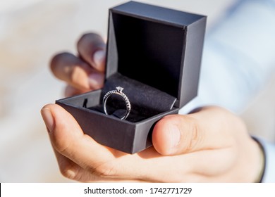 Engagement ring for romantic outdoor elopement marriage proposal when man proposing and holding up an engagement ring in box 