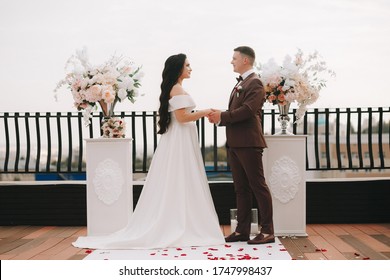 Engagement, wedding, man and woman dress each other in rings. Bride and groom. Hands wedding gold rings with diamonds. Exit registration of marriage on a roof. Against the background of the city.