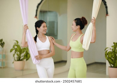 Engaging in Aerial Yoga Class with Smiling Partners - Powered by Shutterstock