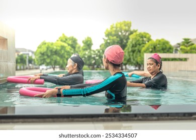 An engaging aquatic exercise class for seniors led by an instructor in a pool. The participants use colorful foam noodles, practicing water-based exercises to stay fit, healthy, and active. - Powered by Shutterstock