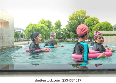 An engaging aquatic exercise class for seniors led by an instructor in a pool. The participants use colorful foam noodles, practicing water-based exercises to stay fit, healthy, and active. - Powered by Shutterstock