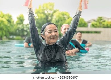 An engaging aquatic exercise class for seniors led by an instructor in a pool. The participants use colorful foam noodles, practicing water-based exercises to stay fit, healthy, and active.