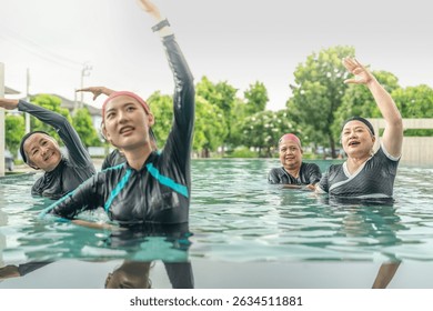 An engaging aquatic exercise class for seniors led by an instructor in a pool. The participants use colorful foam noodles, practicing water-based exercises to stay fit, healthy, and active.