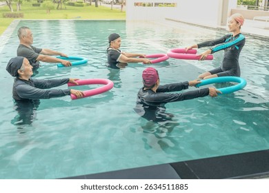 An engaging aquatic exercise class for seniors led by an instructor in a pool. The participants use colorful foam noodles, practicing water-based exercises to stay fit, healthy, and active.