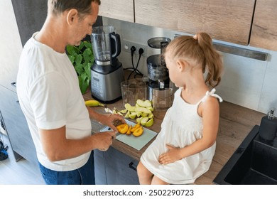 Engaging in Cooking with Kids, A father and his daughter preparing smoothie together in modern home kitchen, Enjoy Quality Time Cooking Together. High quality photo - Powered by Shutterstock