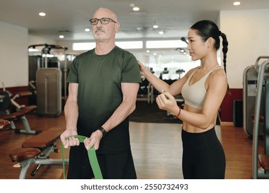 Engaging in Physical Therapy with Resistance Bands in Gym - Powered by Shutterstock