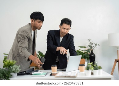 Engaging Presentation and Team Interaction. Professionals collaborating on a laptop in a modern office.