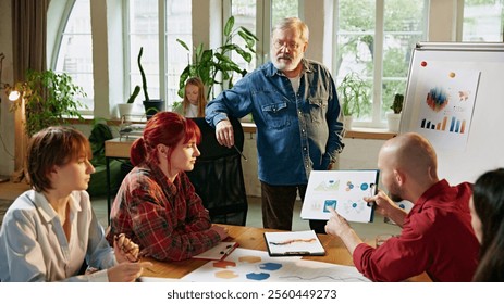 Engaging presentation with visual data, where young professional explains market trends and business goals. Concept of business, consultation, marketing, management, entrepreneurship. Ad - Powered by Shutterstock - Get 15% off with code: PIKWIZARD15