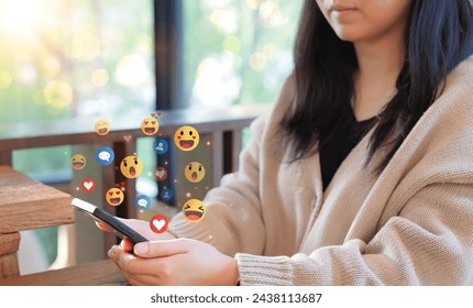 Engaging with social media on the phone. Woman use a smartphone, with social media reactions and emojis floating around, representing online interaction and digital communication. network application, - Powered by Shutterstock