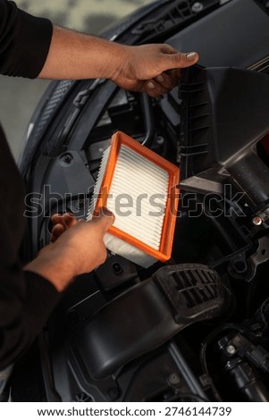 Engine air filter replacement car auto shop, maintenance mechanic hands open hood automotive service routine maintenance engine bay professional