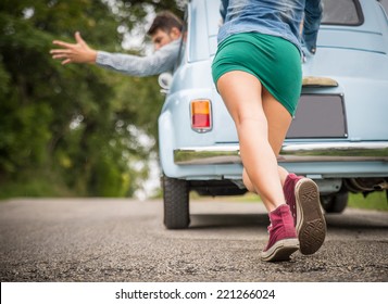 Engine Break Down.Strong Young Woman Pushing A Vintage Car While Man Is Emboldening Her.Transportation,teamwork,funny Concept