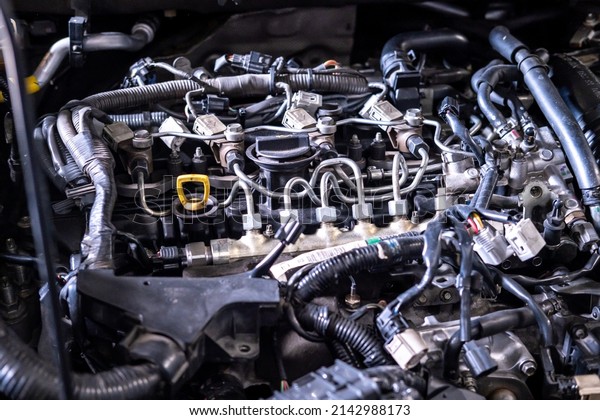 Engine car service mechanic maintenance\
inspection service maintenance car Check engine oil level car in\
garage showroom dealership blurred\
background.