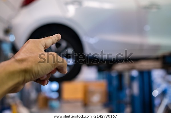 Engine car service mechanic maintenance\
inspection service maintenance car Check engine oil level car in\
garage showroom dealership blurred\
background.