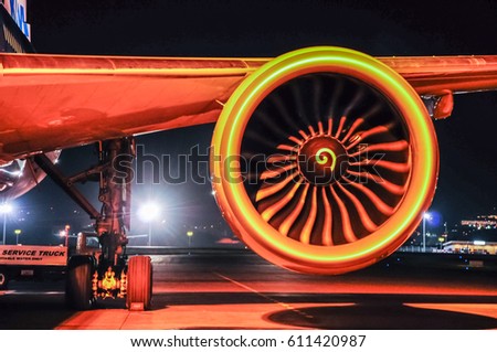 Engine and chassis of passenger jet plane in the night. Front view. Aircraft air intake and fan blades close up.