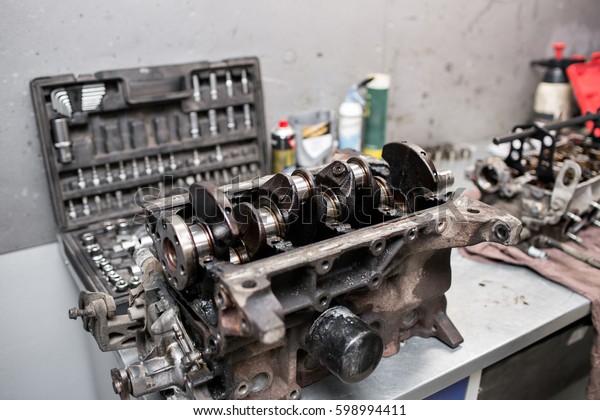 Engine crankshaft,\
valve cover, pistons. mechanic repairman at automobile car engine\
maintenance repair work