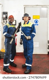 Engine department crew posing together in vessel maintenance area.
