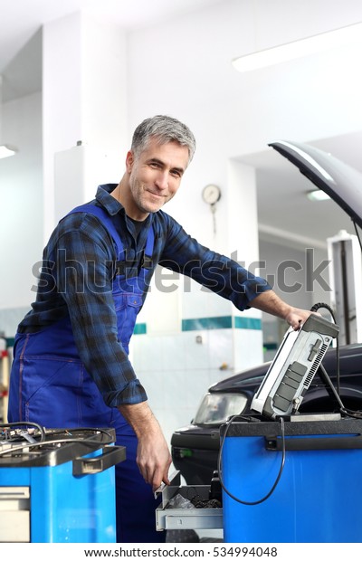 Engine diagnostics. Car in diagnostic station, mechanic\
connected device 