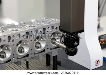 Engine dimensions inspecting on bridge CMM machine. Coordinate measuring machine inspecting automotive engine part. Selective focus.
