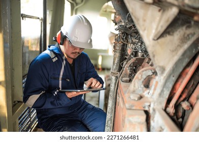 Engine engineer inspecting large machines in factory,Railway engine maintenance technician,engine repair mechanical manager