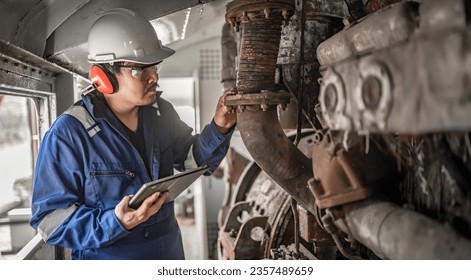 Engine engineer inspecting large machines in factory,Railway engine maintenance technician,engine repair mechanical manager