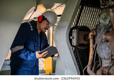 Engine engineer inspecting large machines in factory,Railway engine maintenance technician,engine repair mechanical manager