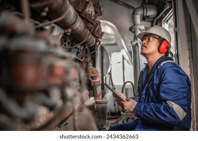 Engine engineer inspecting large machines in factory,Railway engine maintenance technician,engine repair mechanical manager