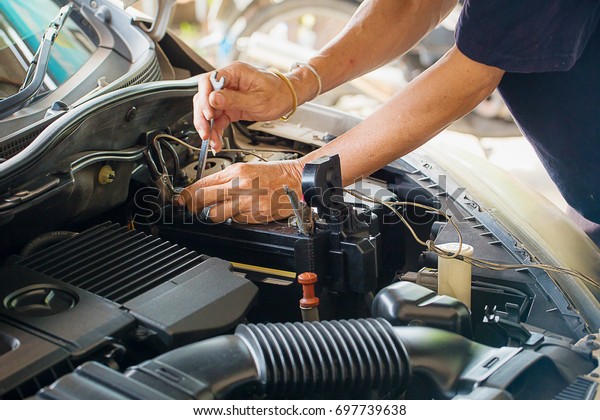 Engine\
engineer is replacing  car battery because car battery is depleted.\
concept car maintenance And the cost of car\
care.