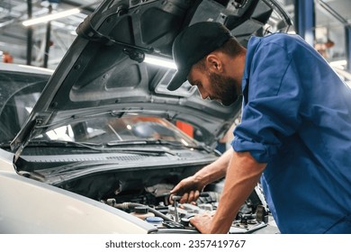 Engine fix. Auto mechanic working in garage. Repair service.