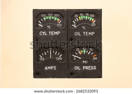 Engine indicating gauges with tiny needles and colored operating arcs. Small indicators point to temperatures and pressures measuring in degrees, PSI, and amps. Old school aircraft instrument