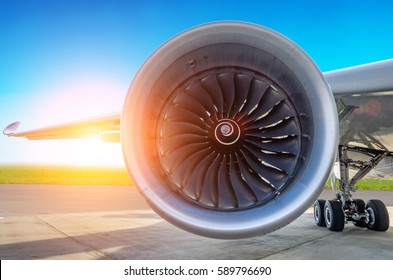 Engine of the modern aircraft close up and the sunset in the sky