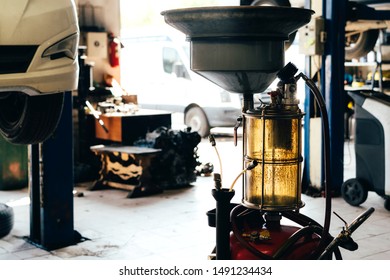 Engine Oil Drain Unit. Car On A Lift In A Car Service.