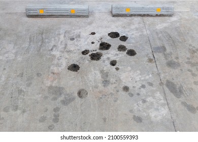 engine oil leakage on concrete floor. Black engine oil on concrete floor. Engine oil leak from the engine. surface concrete with the motor oils stain grey black silver.