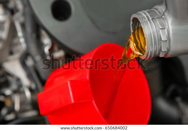 Engine oil pouring\
from canister, closeup
