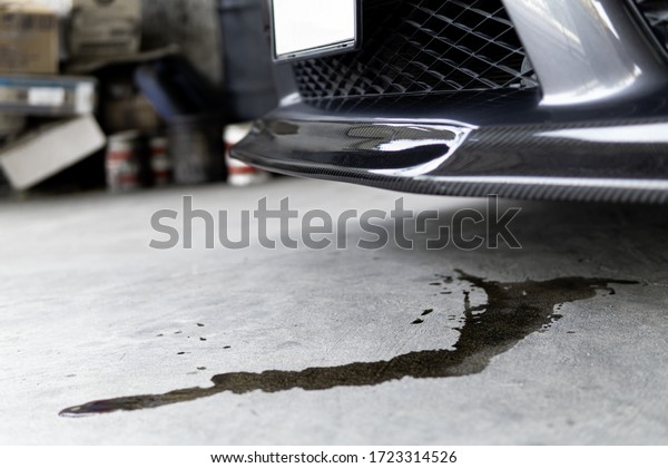 Engine oil stains of car Leak under the car\
when the car is park In the garage service floor photo concept for\
check and maintenance